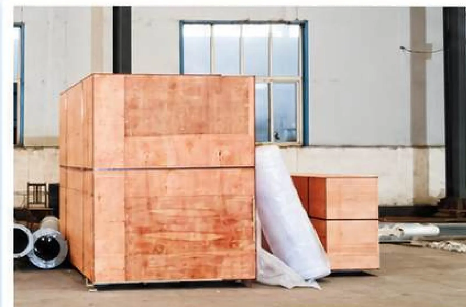 Embalaje de exportación de equipos de servicios del sitio en una caja de madera contrachapada con envoltura protectora, dentro de un taller