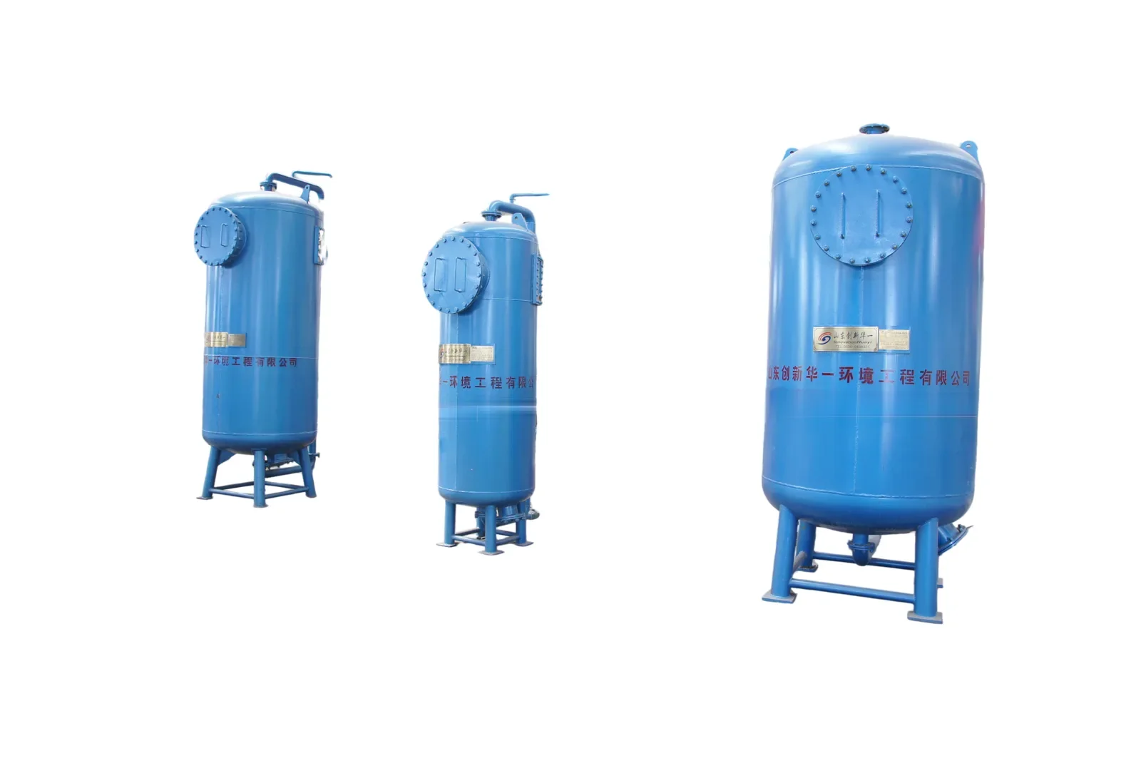 Three blue mechanical filter vessels with bolted manway covers on leg supports
