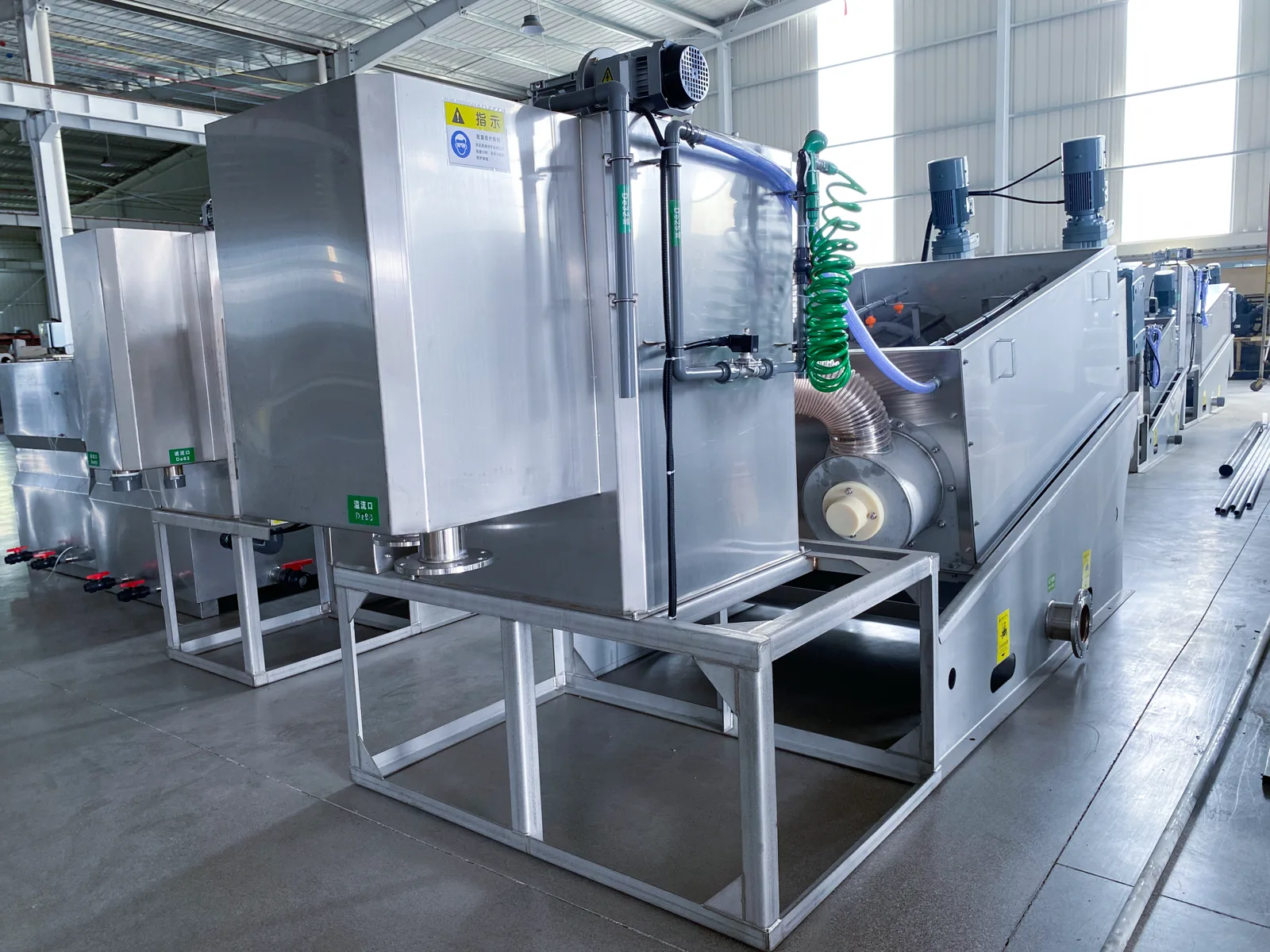 CXDL screw press dewatering machines in a row in our workshop, each with its tank, drive and pipework